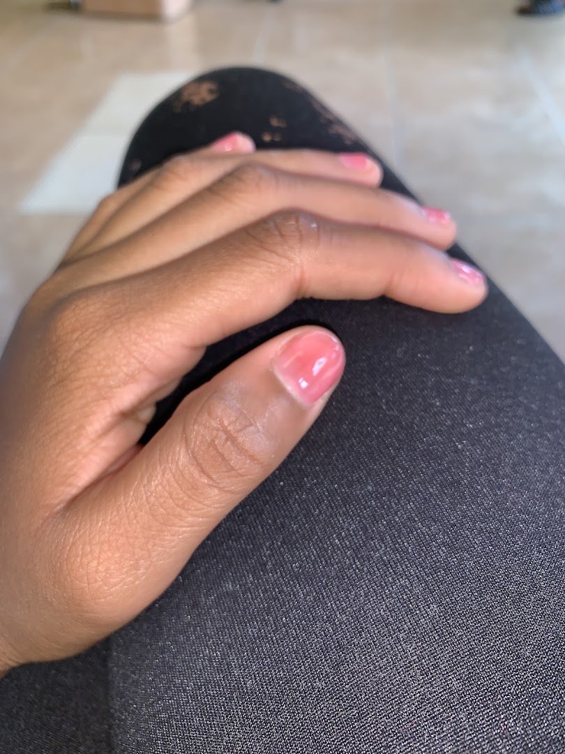 Nail technician shaping a fresh manicure.