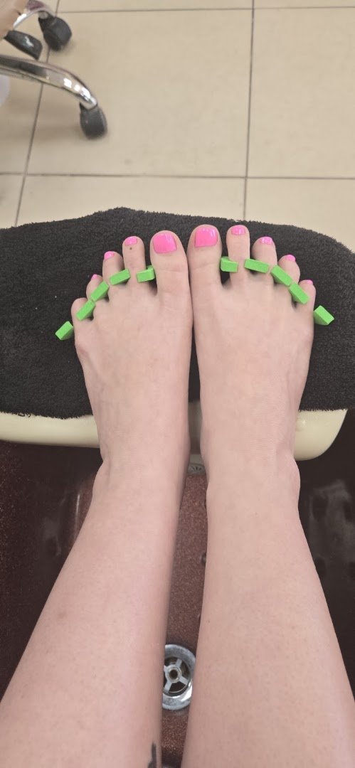 Manicured nails under soft salon lighting.